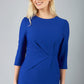 blonde model is wearing diva catwalk logan round neck sleeved pencil dress with side arrow pleating detail in royal blue front