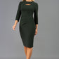 A blonde Model is wearing a cut out peep hole neckline pencil dress with pleating across the tummy area and 3/4 sleeve lenght sleeve in green