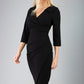 blonde model is wearing diva catwalk liesel wrap pencil sleeved dress with collar half way around low v-neck in black front