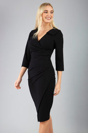 blonde model is wearing diva catwalk liesel wrap pencil sleeved dress with collar half way around low v-neck in black front
