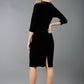 A blonde model is wearing a velvet pencil sweetheart neckline dress by diva catwalk in black back image