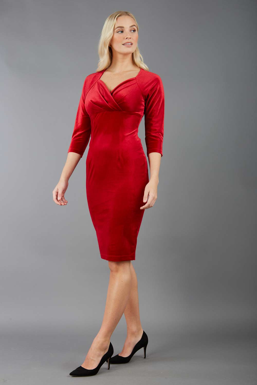 A blonde model is wearing a velvet pencil sweetheart neckline dress by diva catwalk in red 