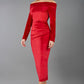 A blonde Model is wearing an off shoulder bardot neckline velvet stretch midi dress in red by diva catwalk