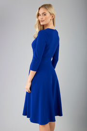 blonde model is wearing diva catwalk january sleeved a-line v-neck dress in cobalt blue back