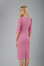 blonde model is wearing diva catwalk lucretis rounded neckline sleeved pencil dress with  rushing on shoulders and rushed detail on a side of a waistline in pink back