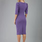 blonde model is wearing diva catwalk lucretis rounded neckline sleeved pencil dress with  rushing on shoulders and rushed detail on a side of a waistline in lavender purple back