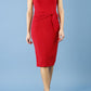 model is wearing diva catwalk Ester cap sleeve pencil dress with v-neck and bow detail at the front in tango red front