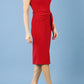 model is wearing diva catwalk Ester cap sleeve pencil dress with v-neck and bow detail at the front in tango red side