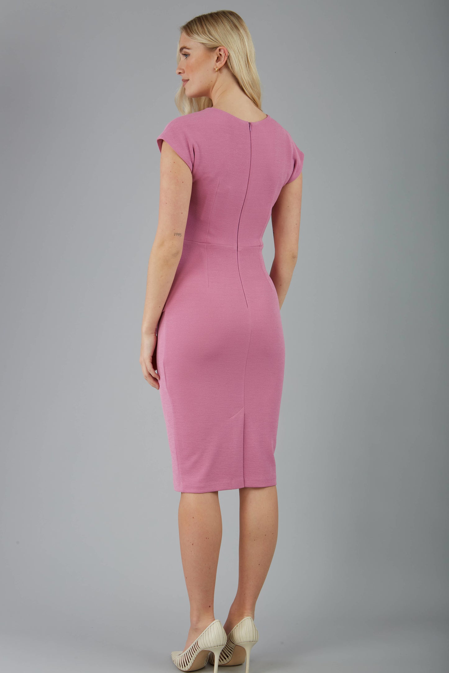 model is wearing diva catwalk Ester cap sleeve pencil dress with v-neck and bow detail at the front in cashmere pink back