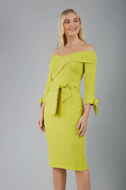blonde model is wearing diva catwalk mulberry pencil off-shoulder dress with a bow detail on 3/4 sleeves and criss cross on a front panel in lime front