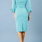 blonde model is wearing diva catwalk mulberry pencil off-shoulder dress with a bow detail on 3/4 sleeves and criss cross on a front panel in aqua green back