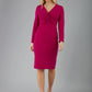 blonde model is wearing diva catwalk gately pencil dress with long sleeves and twisted low v-neck in magenta front