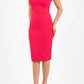 brunette model wearing diva catwalk rosita pencil skirt fitted dress with asymmetric neckline and bow detail at the top and it is a sleeveless design  with empire waistline in pink front