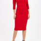 A model is wearing a three quarter sleeve pencil dress with a round neckline and bow detail at the front in red