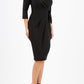 model wearing diva catwalk elan elegant black dress with 3 4 sleeves with a tie detail and asymmetrical closing front