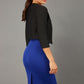 brunette model wearing diva catwalk black sleeved bolero over a royal blue pencil dress front