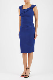 brunette model wearing diva catwalk rosita pencil skirt fitted dress with asymmetric neckline and bow detail at the top and it is a sleeveless design  with empire waistline in navy blue colour front
