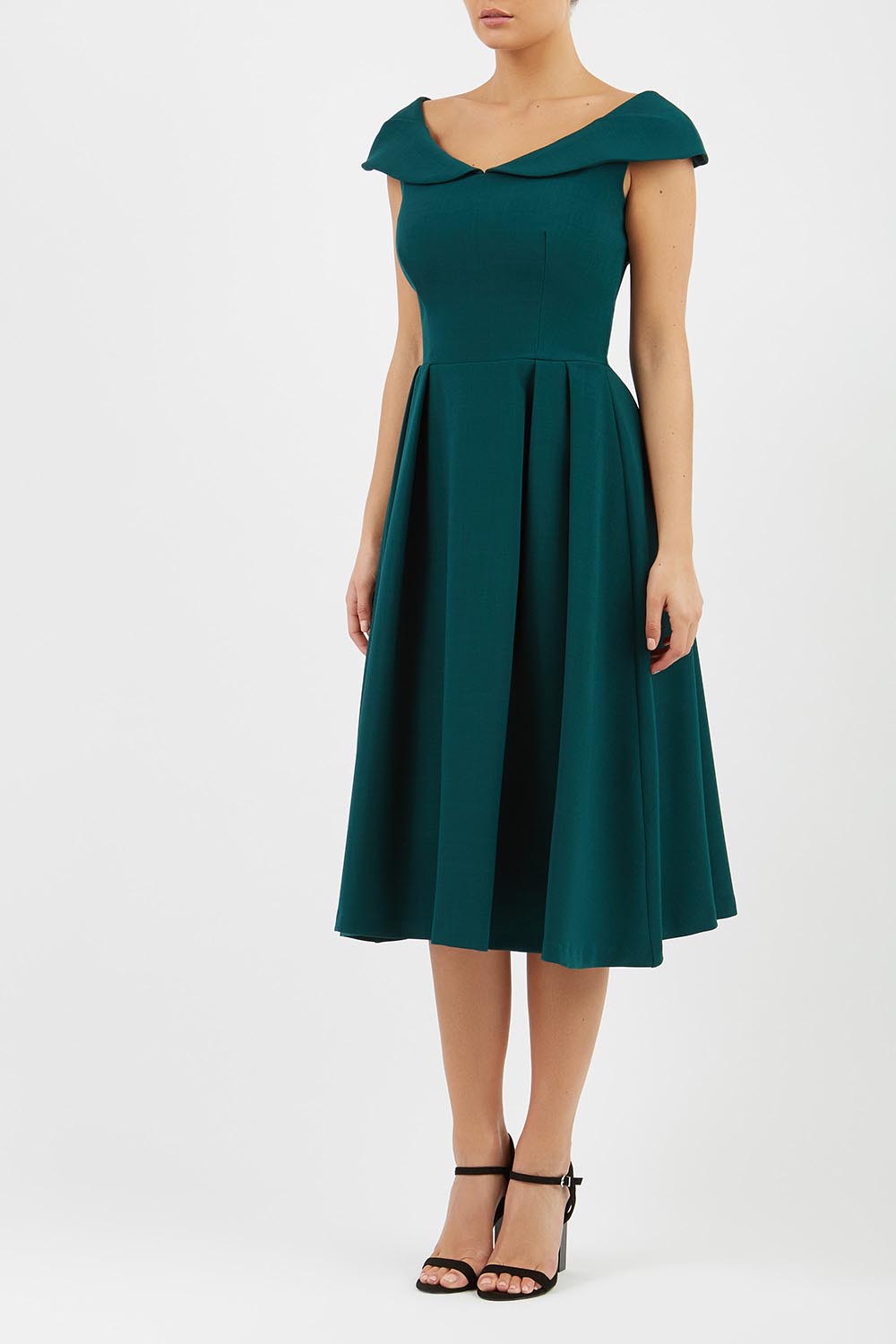 Model wearing the Diva Chesterton Sleeveless dress with oversized collar detail and swing pleated skirt in forest green front image