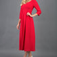 Brunette Model is wearing 3/4 sleeve sweetheart neckline swing electric red dress
