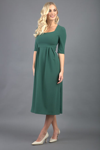 model wearing a diva catwalk Padstow Midi A-line Dress elbow length sleeves and midi length with empire waistline in hunter green colour