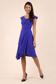 brunette model wearing diva catwalk abaline asymmetric swing sleeveless dress with asymmetric collar neckline detail in spectrum indigo front
