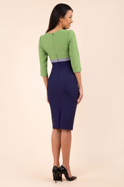 brunette model wearing seed lara pencil colour block dress three quarter sleeve and pleating across the body with split neckline in navy blue and citrus green and sky grey back