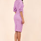 brunette model wearing diva catwalk palacio pencil fitted dress with three quarter puffed sleeve and pleating across the body with overlapping v-neckline in pink polka dot back