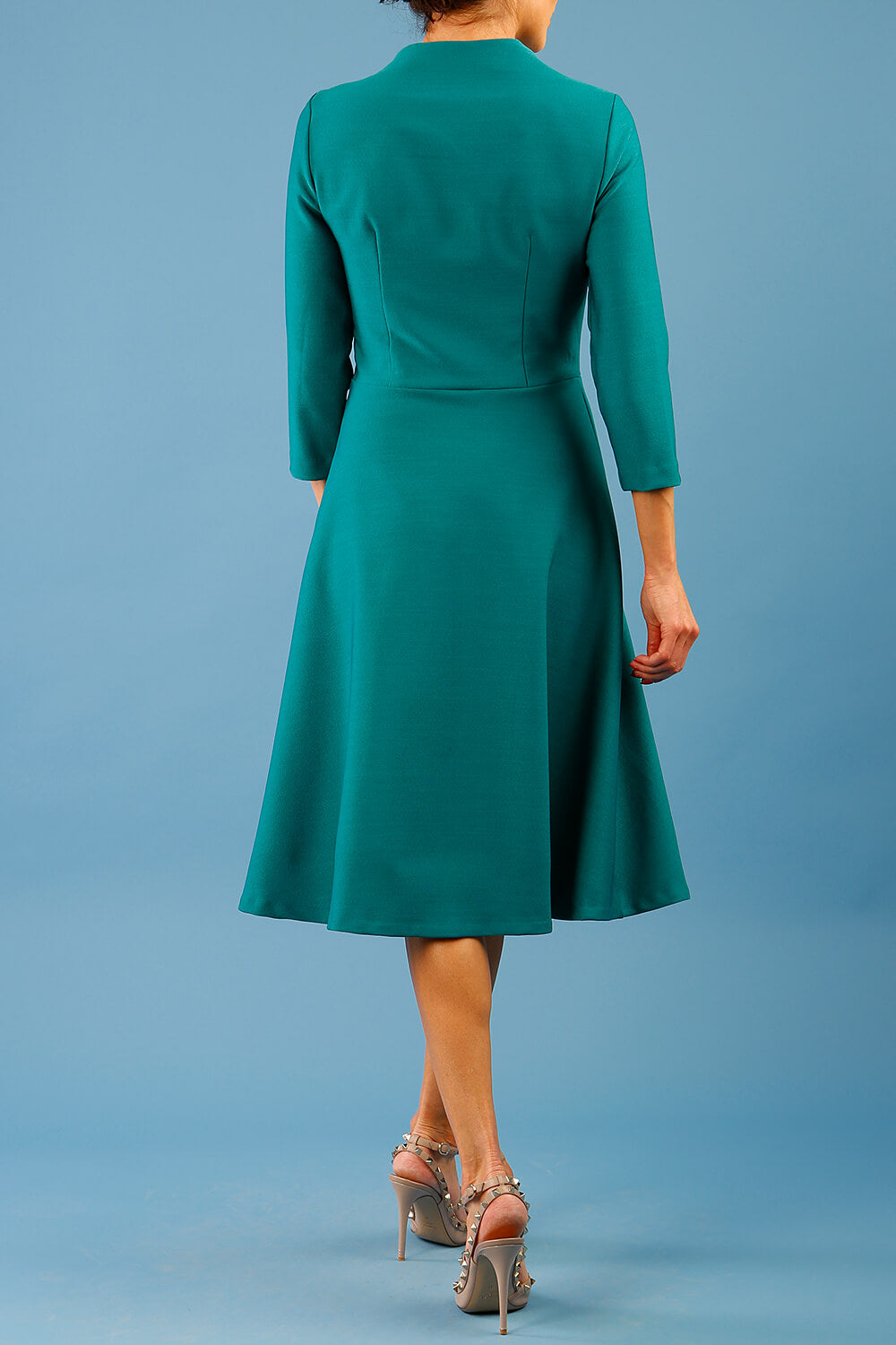 model is wearing diva catwalk palmerston vintage style a-line dress with sleeves and high neck with a slit in pacific green colour back