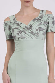 Model wearing the Diva Amorette pencil dress with cold shoulder and pleated detailing on the arms in deco green fern front image