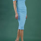 Model wearing the Diva Atlas Pencil dress with round neckline short sleeved dress with small cutouts on the shoulders in crystal blue back
