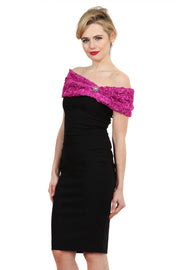 Model wearing the Diva Cornelli Perth dress with cornelli lace top, off shoulder design and diamanté brooch in black and fushia pink front image