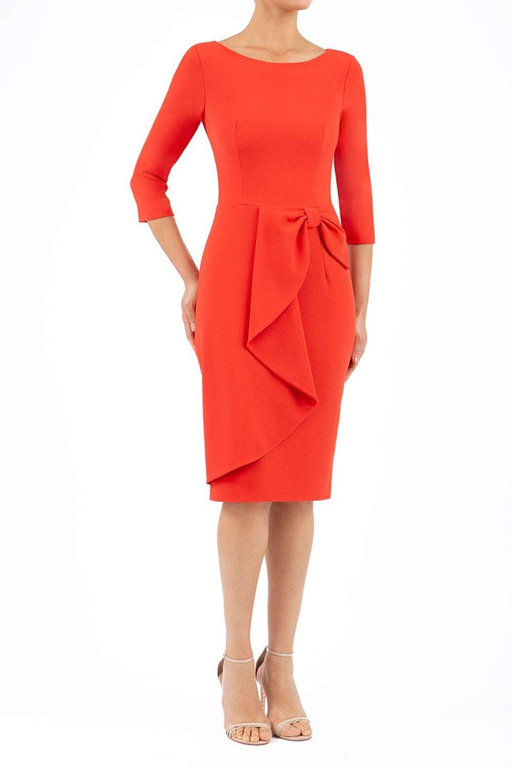 model is wearing diva catwalk jacky dress with rounded neckline 3/4 sleeve and bow detail on the waist in fiesta orange front 