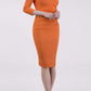 brunette model wearing diva catwalk best selling lydia pencil sleeved dress with slit at the neckline and pleating across the tummy in colour orange front