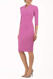 brunette model wearing diva catwalk best selling lydia pencil sleeved dress with slit at the neckline and pleating across the tummy in colour begonia pink front