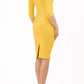 brunette model wearing diva catwalk best selling lydia pencil sleeved dress with slit at the neckline and pleating across the tummy in colour mustard yellow back