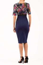 model wearing diva catwalk nadia fitted pencil dress made in the uk with short sleeves and pleated pencil skirt in navy and black back