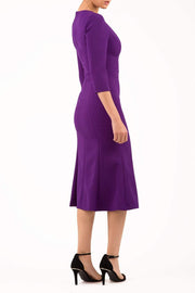blonde model is wearing diva catwalk senne midaxi sleeved dress with fishtail and rounded neckline with a slit in the middle in royal purple side
