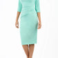 brunette model wearing diva catwalk ubrique pencil dress with a keyhole detail and sleeves in mint green front