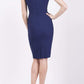 blonde model is wearing diva catwalk vivian sleeveless pencil skirt dress with overlapped bust area and lowered neckline in navy blue colour back