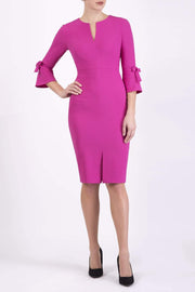 blonde model wearing diva catwalk zoe 3 4 sleeve formal dress with a split rounded neckline and split on skirt in pink colour front