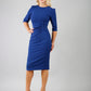 blonde model is wearing diva catwalk lucretis rounded neckline sleeved pencil dress with rushing on shoulders and rushed detail on a side of a waistline in midnight blue front