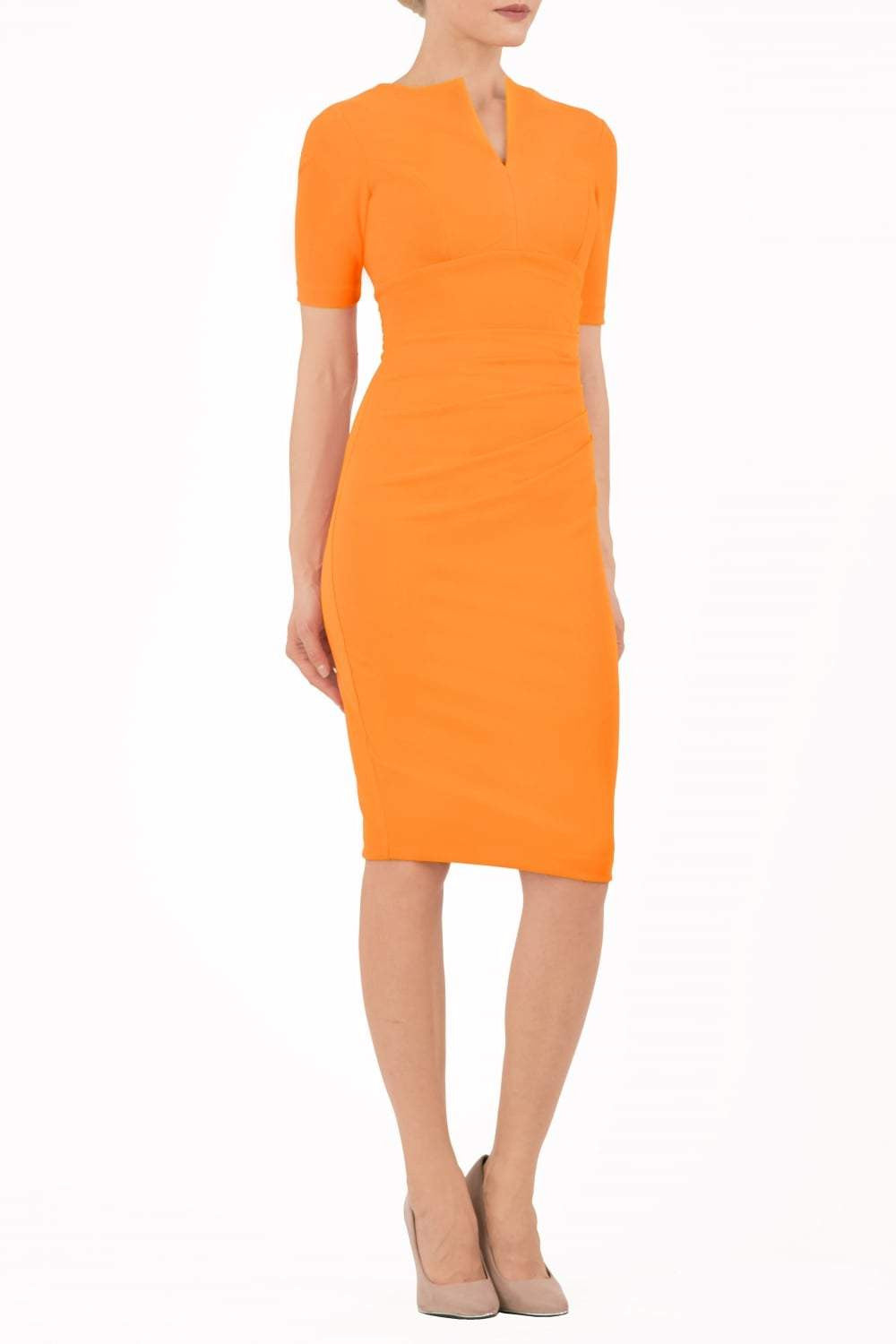 model is wearing diva catwalk lydia short sleeve pencil fitted dress in sun orange colour with rounded neckline with a slit in the middle back