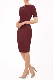 model is wearing diva catwalk lydia short sleeve pencil fitted dress in burgundy colour with rounded neckline with a slit in the middle back
